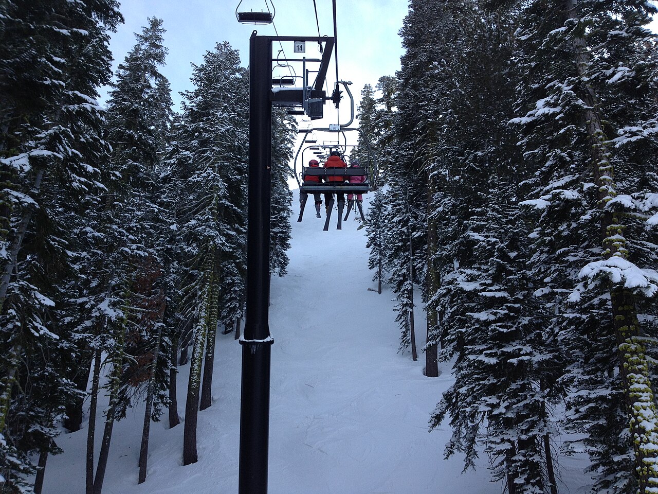Palisades Tahoe, Olympic Valley — chairlift through snowy trees. Photo: http://tahoesignatureproperties.com/. Archive image; resized.