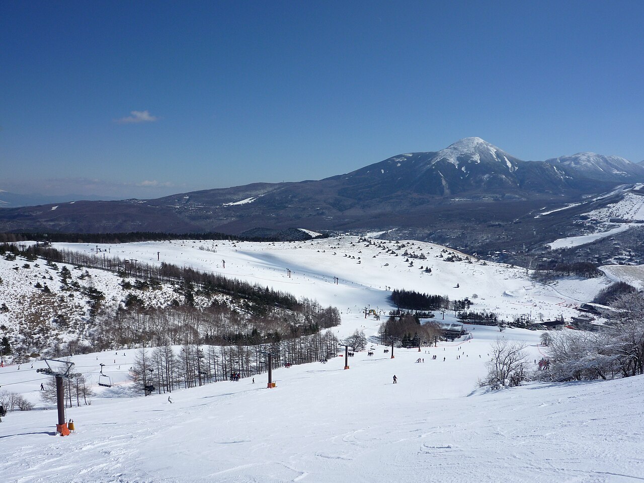 Kurumayama Kogen SKYPARK — snowy slopes with Mount Tateshina beyond. Photo: Ski Mania. Archive image; resized. Public domain.